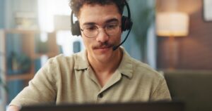 man with headset looking at computer