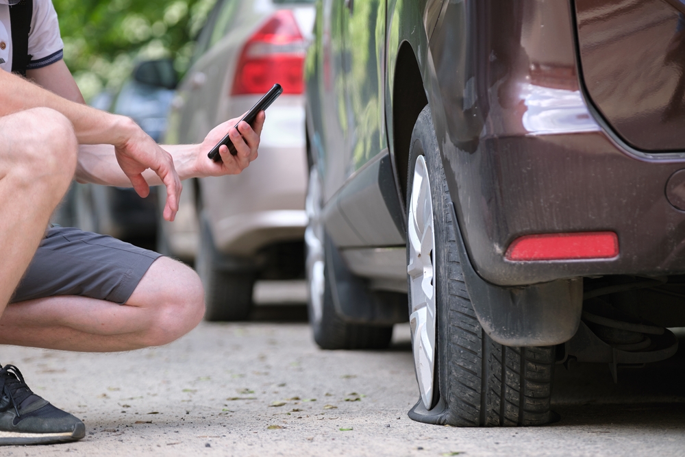 man taking picture of flat tire